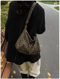 Outdoor shot of leopard print canvas hobo bag with adjustable strap and zipper closure