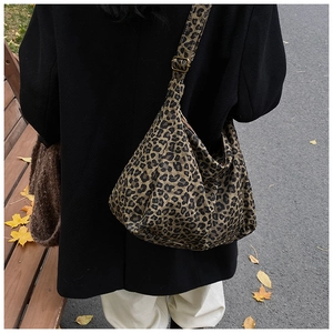 Outdoor lifestyle view of a large leopard print canvas tote bag worn over the shoulder