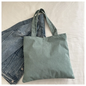 Detail view of mint green corduroy tote bag showing fine ribbed texture and soft handles