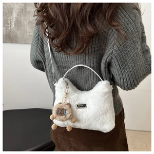 Détail du sac en peluche blanc avec logo sport et pendentif ours en peluche marron