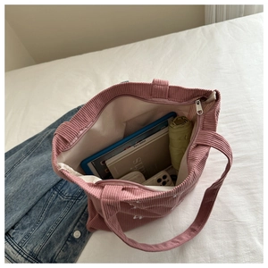 Detail of pink corduroy tote bag interior with zipper closure and spacious compartment