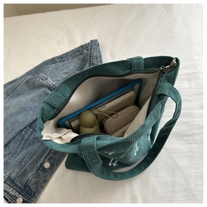 Spacious interior of corduroy tote bag showing storage for tablets and daily items