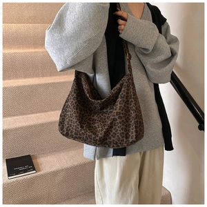 Macro shot of leopard print canvas bag detailing texture and adjustable black strap