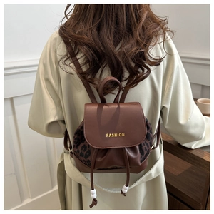 Detail of leopard print backpack with brown leather flap and stylish drawstring closure