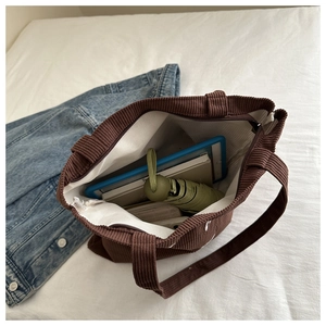 Interior detail of a brown corduroy tote bag showing large capacity and zipper closure