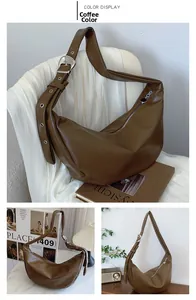 Detail of adjustable shoulder strap and silver metal buckle on coffee brown Hobo bag