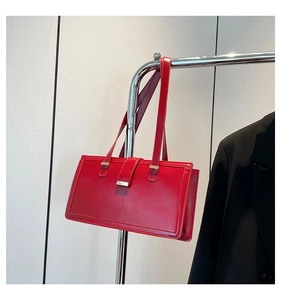 Detailansicht einer roten Lackleder-Achseltasche mit Metallschnalle am Kleiderbügel