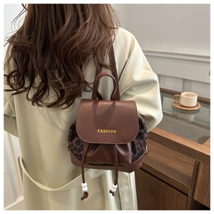 Detailed back view of leopard print backpack with brown leather flap and fashion text