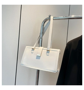 Detail der weißen rechteckigen Schultertasche mit Lederriemen und goldener Schnalle