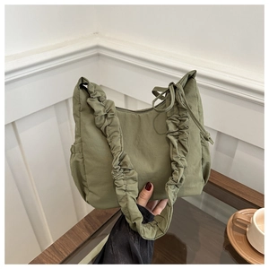 Detail of olive green nylon tote bag featuring ruched cloud-style shoulder strap design
