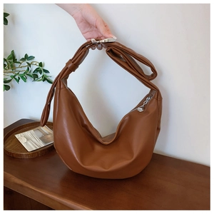 Caramel hobo bag detail with wide knotted shoulder strap and smooth leather finish