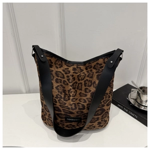 Macro view of leopard print bucket bag with black strap and metallic rivet details