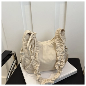 Detail of ruffle nylon shoulder bag showing dense pleated strap and metal zipper