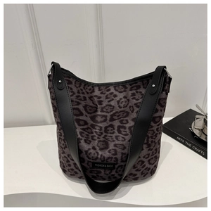 Detail of leopard print tote bag with wide leather strap and silver rivet accents