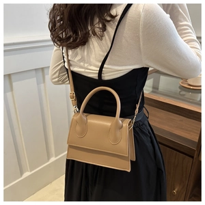 Model wearing a khaki crossbody bag showcasing the size and strap length from behind