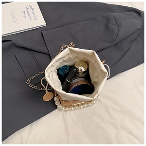 Detail view of box bag interior showing capacity for cosmetics and pearl handle