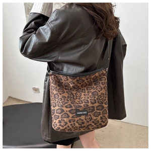 Détail du sac cabas léopard avec bandoulière noire porté avec une veste en cuir vintage