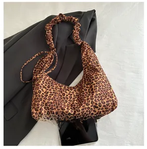 Detail of trendy leopard print crescent bag with stylish ruched scrunchie handle