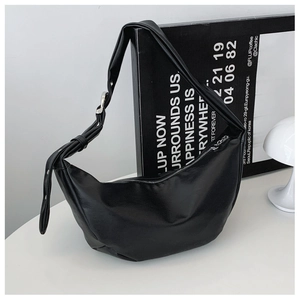 Close-up of a matte black crescent shoulder bag with silver buckle and leather strap