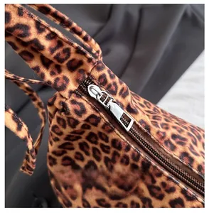 Detail shot of the smooth silver metal zipper on the leopard print tote bag fabric
