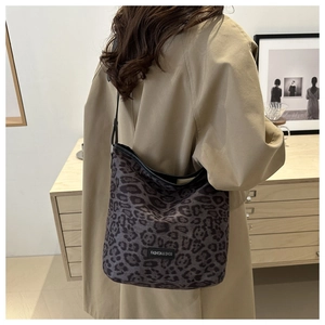 Detail of leopard print hobo bag with a fashion tag and slim black leather shoulder strap