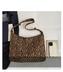 Detailed view of large leopard print canvas tote bag size comparison with smartphone