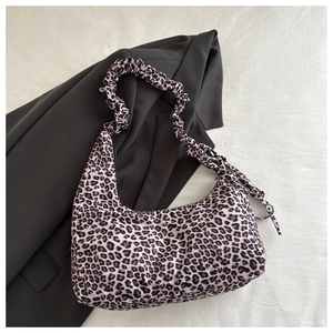 Detail of leopard print hobo bag featuring a stylish scrunchie strap and side ribbon
