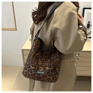 Leopard print tote bag with wide black shoulder strap shown on model in modern room