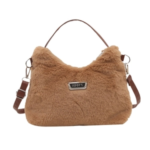 Sac à main en peluche marron avec anses en cuir et étiquette sport sur fond blanc