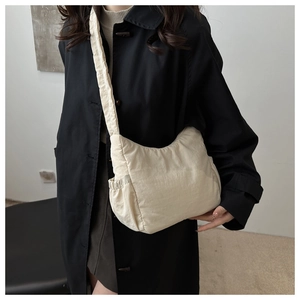 Detail of off-white quilted nylon tote bag with side drawstring pocket and shoulder strap
