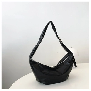 Detail of black crescent shoulder bag with smooth PU leather texture and silver buckle