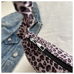 Close-up of leopard print satin handbag with silver zipper and scrunchie style handle