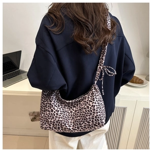 Detail of leopard print hobo bag with a decorative bow knot on the shoulder strap