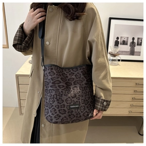 Detail of grey leopard print fabric tote bag with fashion tag and black leather straps
