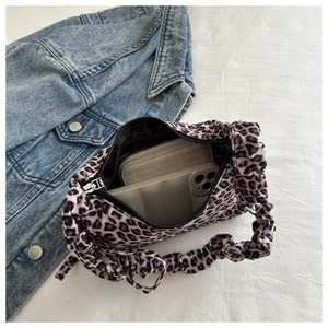 Detailed interior view of leopard print baguette bag showing phone and wallet storage capacity