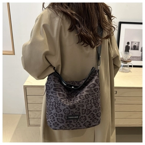 Macro shot of leopard print faux suede shoulder bag with black strap and fashion label