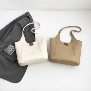 Minimalist faux leather tote bag in beige and khaki colors with brown buckle detail