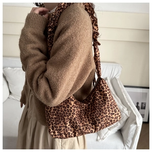 Detail of leopard print canvas bag with pleated ruffles on the shoulder strap