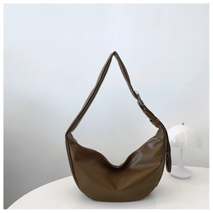 Detailed close-up of brown matte hobo bag with wide shoulder strap and silver metal buckle