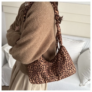 Detailed view of leopard print tote bag with ruffled shoulder strap worn by a model