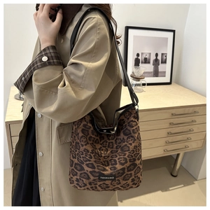 Close-up of leopard print shoulder bag featuring leather straps and fashion label