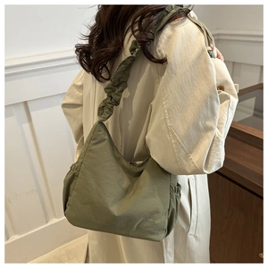 Detailed view of army green nylon cloud bag with ruched scrunchie shoulder strap
