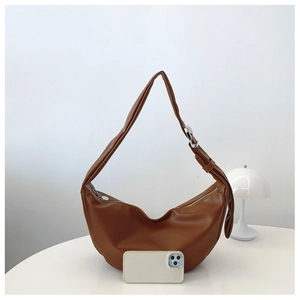 Brown half-moon hobo bag with adjustable strap and mobile phone for size scale