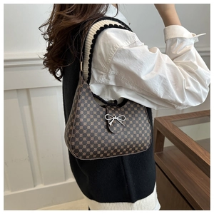 Detail of dark brown crescent bag with retro geometric pattern and silver bow charm