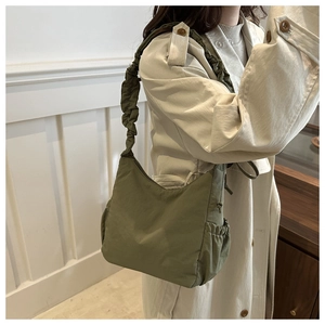 Detail of army green nylon crescent bag with ruffled shoulder strap and side drawstring pocket