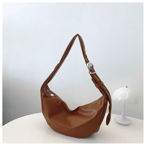 Brown semi-circle hobo bag featuring smooth leather texture and adjustable strap detail