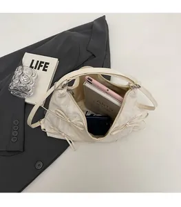 Détail de l'intérieur du sac à nœud crème montrant une grande capacité pour tablette et livres