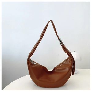 Macro detail of dark brown crescent hobo bag featuring a silver square buckle on the strap