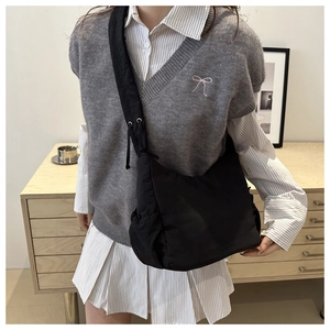Large black nylon crossbody bag with drawstring shoulder strap and side pocket design