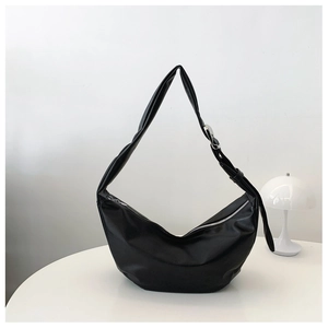 Detail of black crescent hobo bag with adjustable strap and silver metal buckle